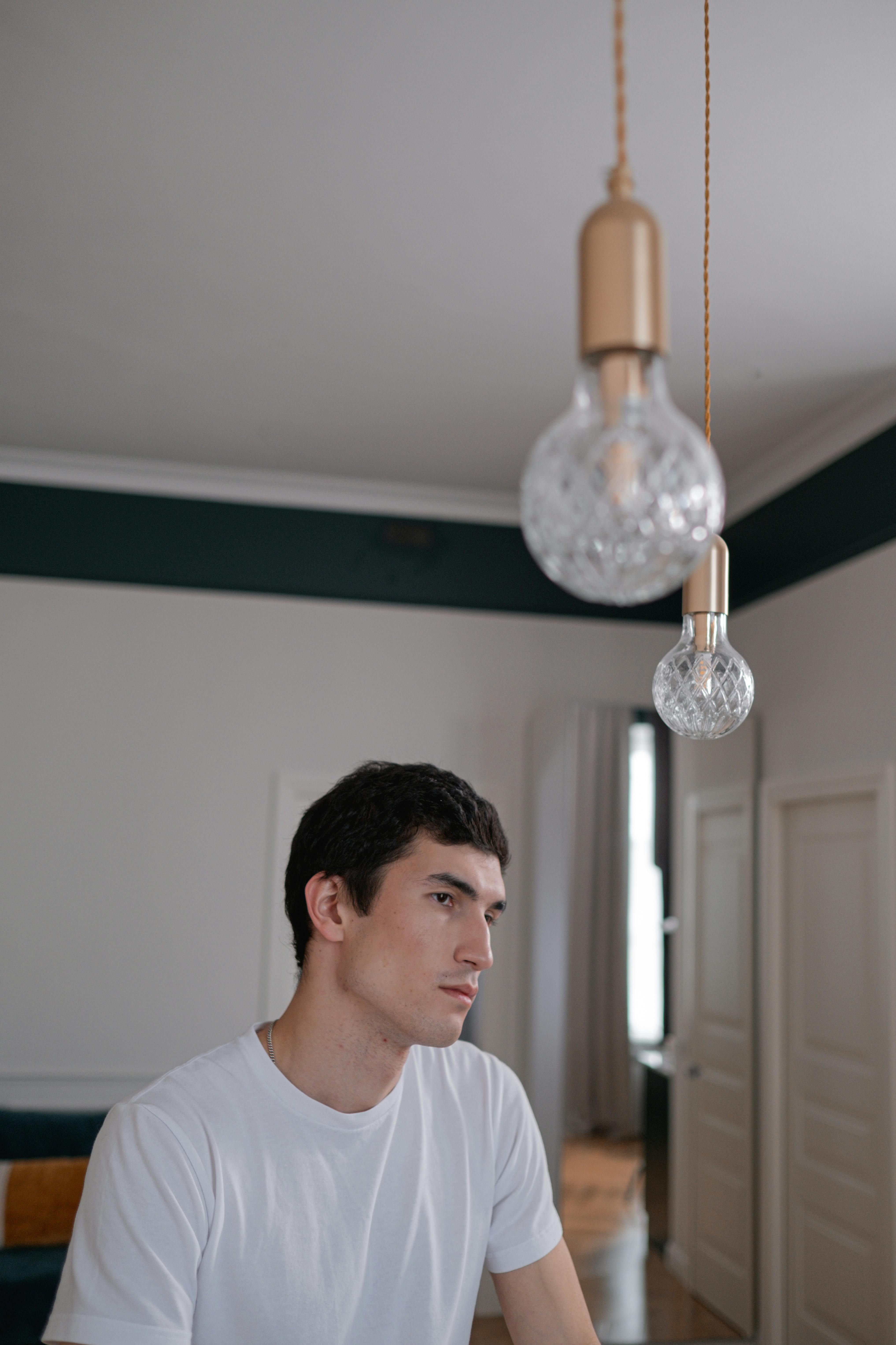 A man sitting in a minimally designed room with bulbs