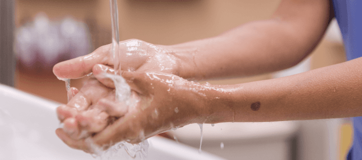 Hands being washed under running water.