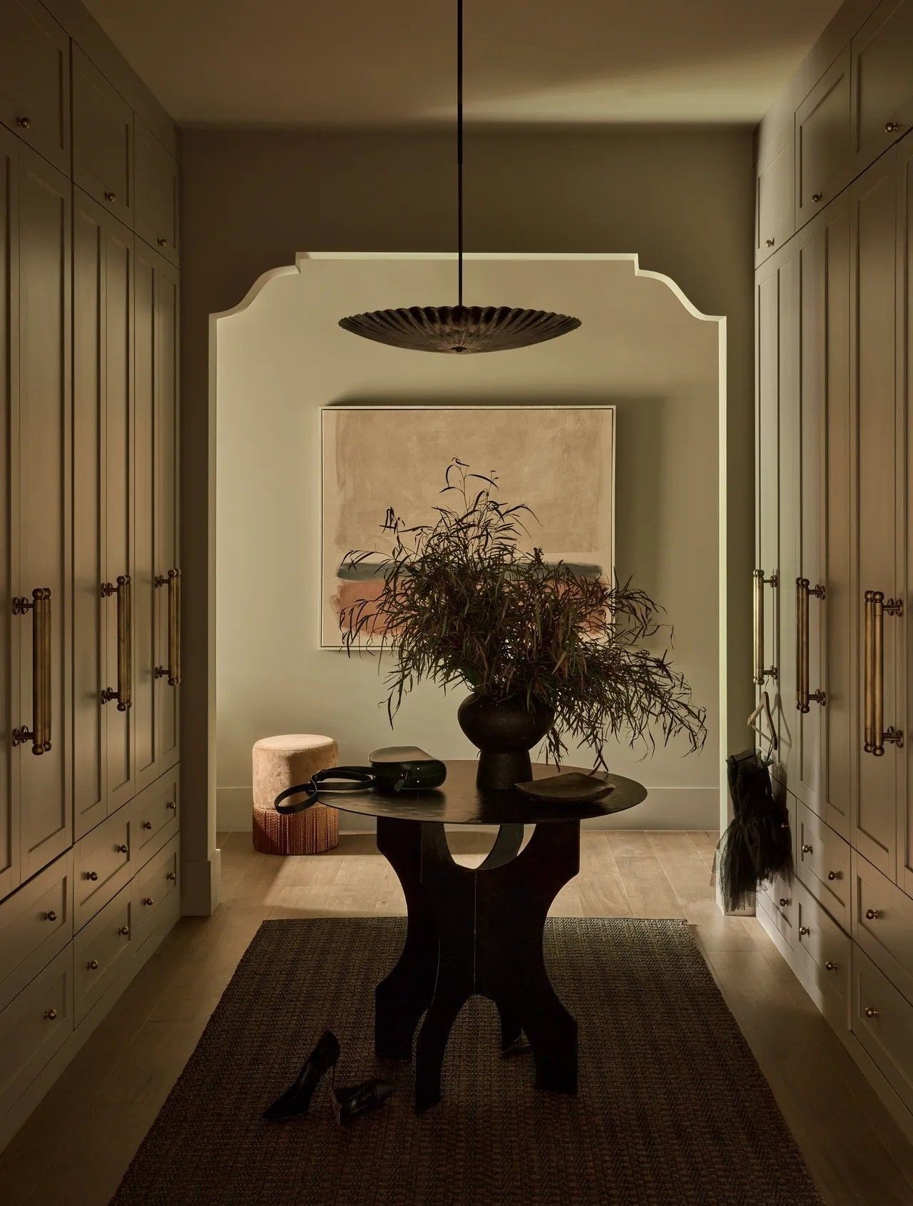 Dark interior with a curtained arch, bar counter, lamp, and small round table.