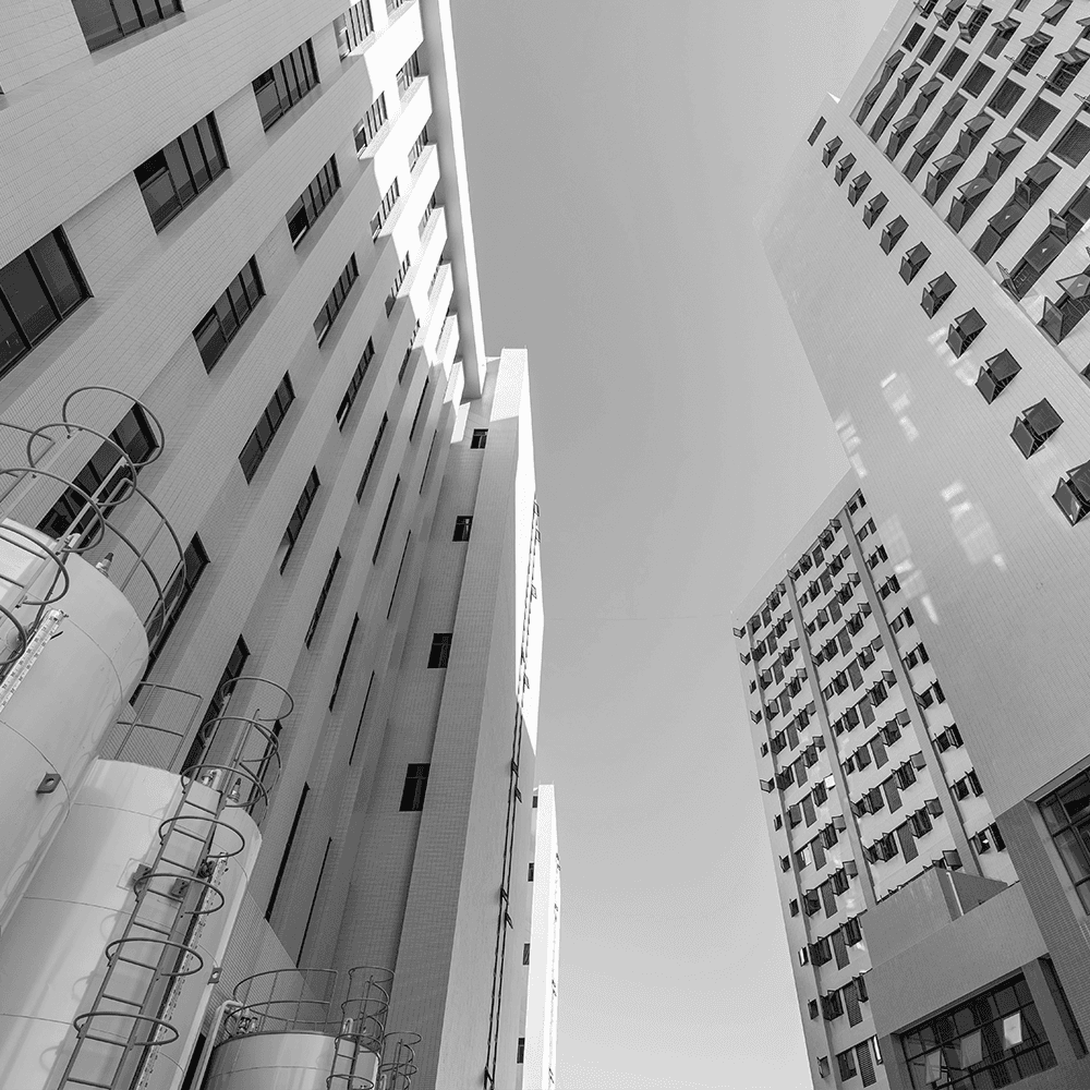 Wide-angle exterior view of a large-scale manufacturing facility with modern architecture and sleek vertical lines, demonstrating significant production and administrative capacity.