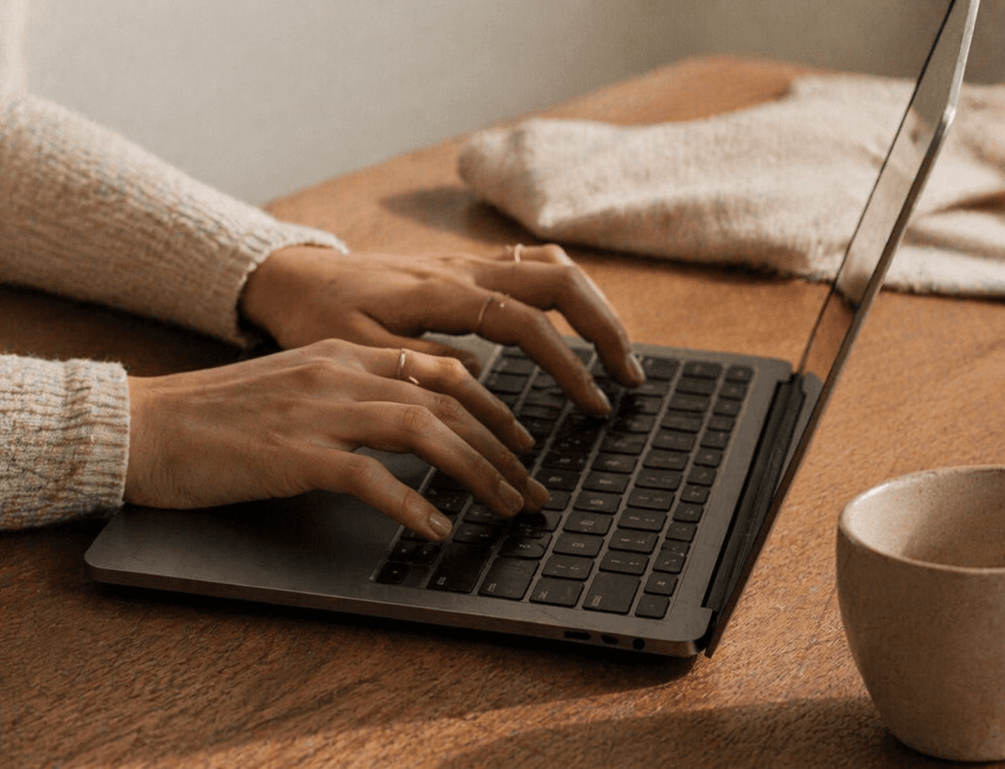 Hands typing on laptop