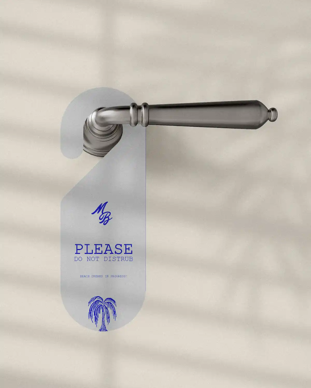 Accroche-porte Marble Blue translucide sur poignée dorée, avec monogramme MB, texte "Please do not disturb" et illustration palmier en bleu cobalt.