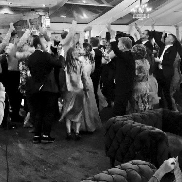 A lively crowd of guests rushing towards the bride and groom in Muskoka, filled with excitement and joy as they celebrate the couple’s special moment.