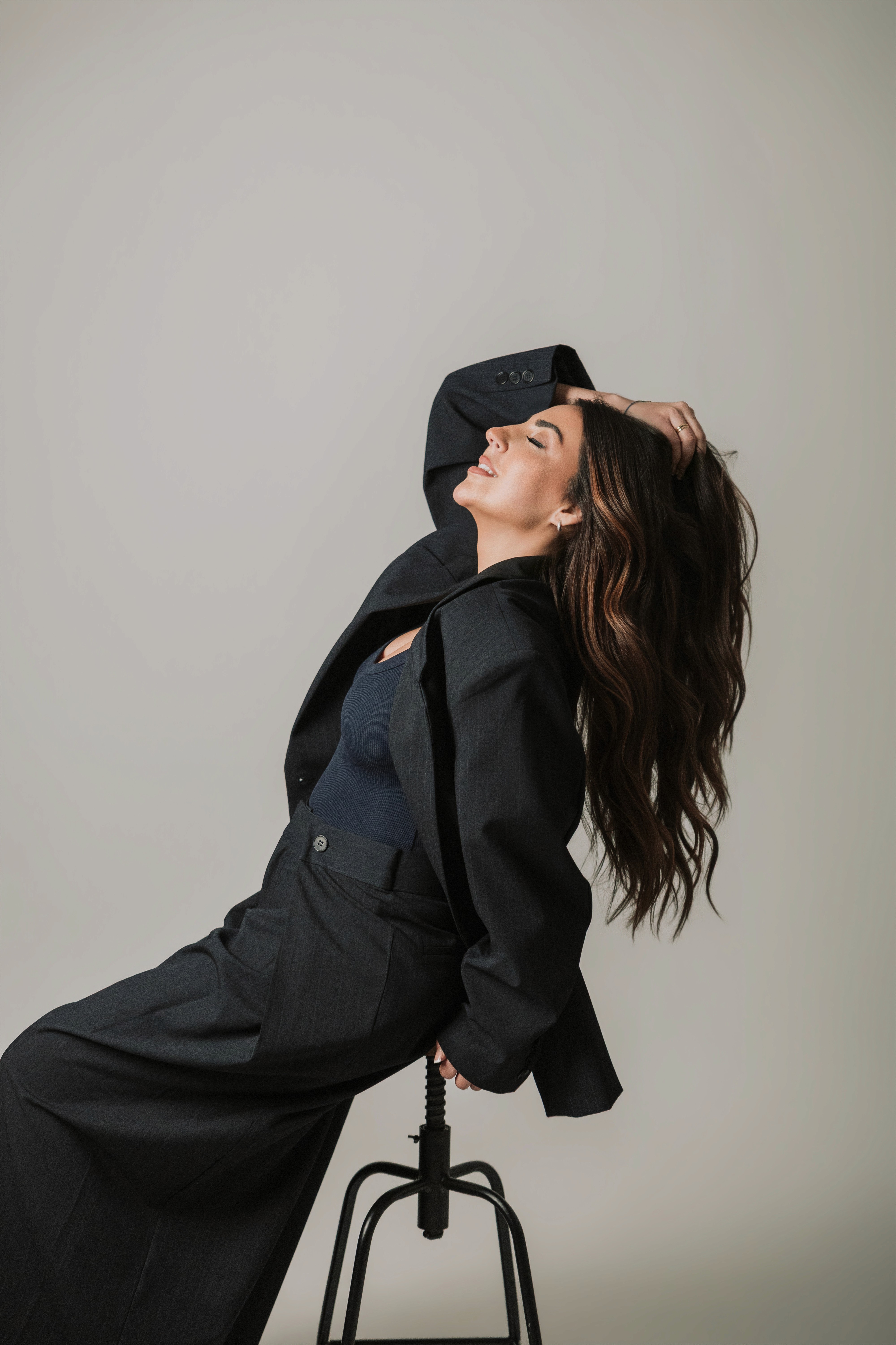 A close-up of a serene face illuminated by soft light, with shadows creating a patterned effect across the skin.