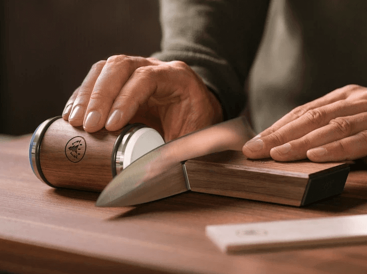 Nahaufnahme einer Person, die den HORL®3 Nuss Rollschleifer mit der extrafeinen Schleifscheibe an einem Messer verwendet, um die Schneide fein abzustimmen und für ein besonders präzises Finish noch weiter zu glätten.