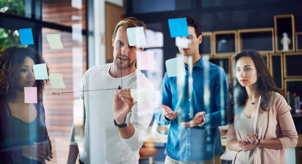 Group of professionals discussing ideas with holographic visuals, representing commitment to best practices and innovation.