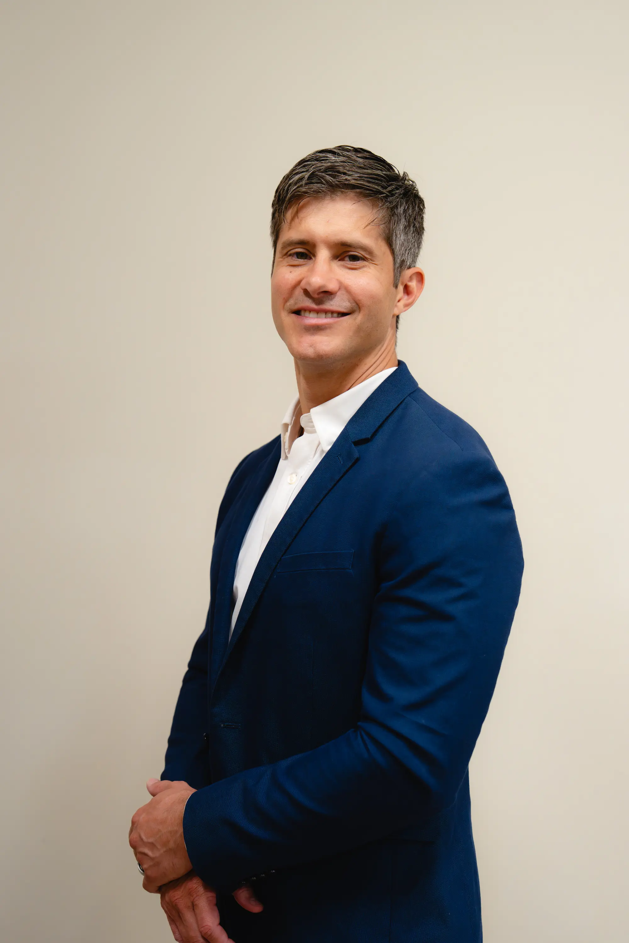 Portrait of a smiling man with grey hair in a blue blazer
