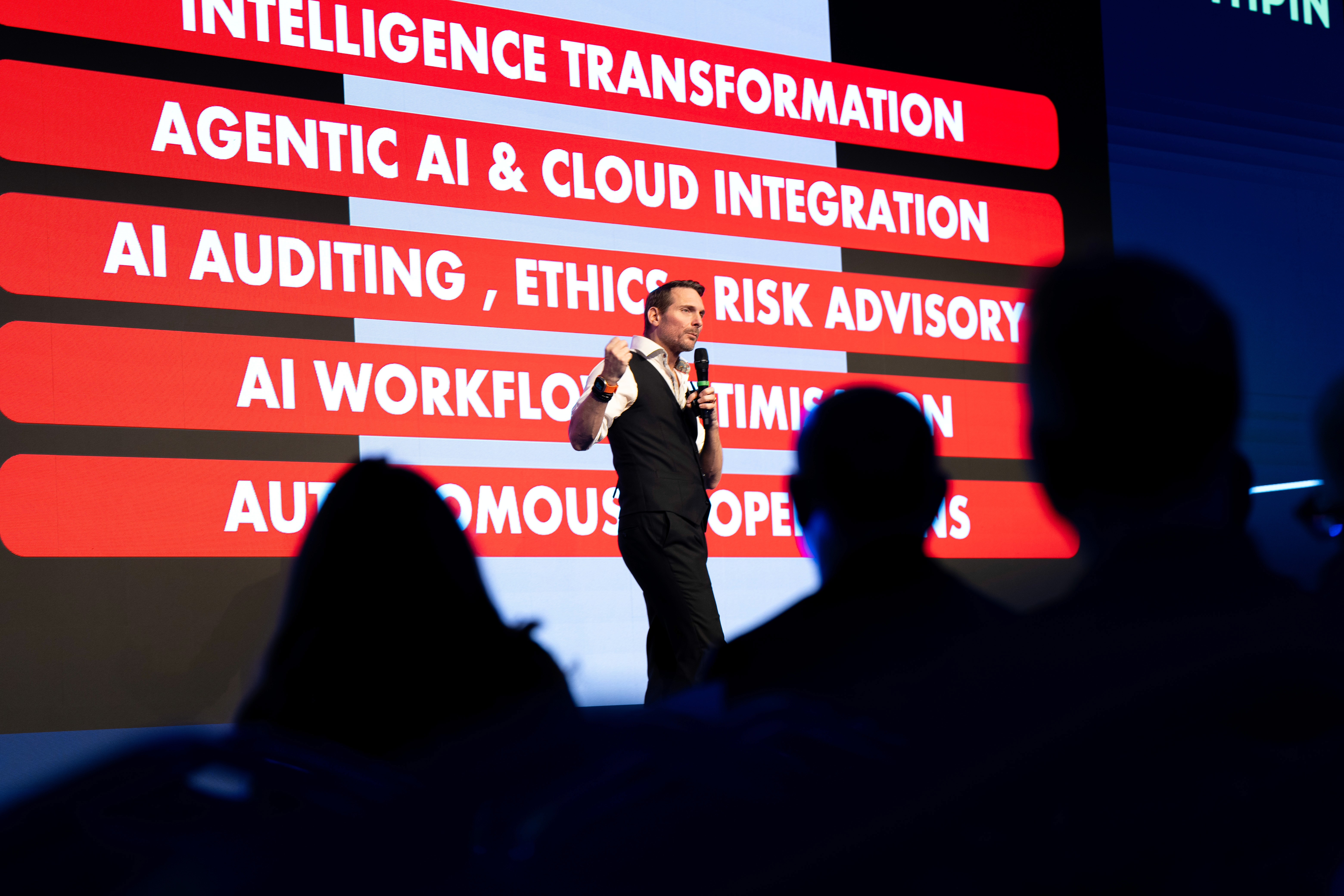 A vibrant event scene with attendees in business attire interacting, one wearing a colorful costume.