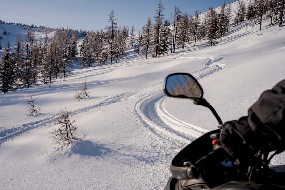 Snowmobile tracks crossing a snow-covered slope in the Western Altai