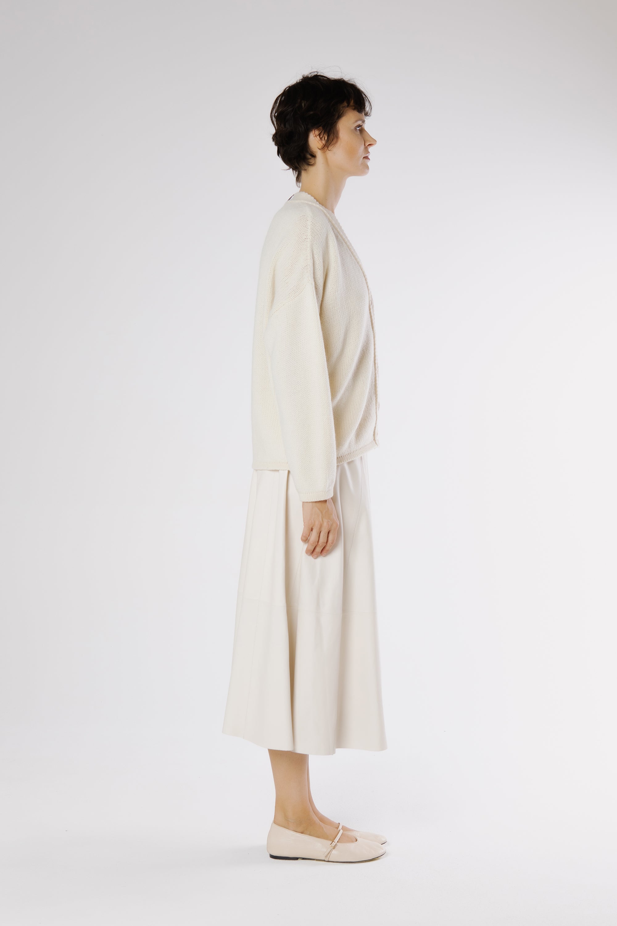 Side view of elegant Milk leather midi skirt highlighting gentle flare and natural movement.