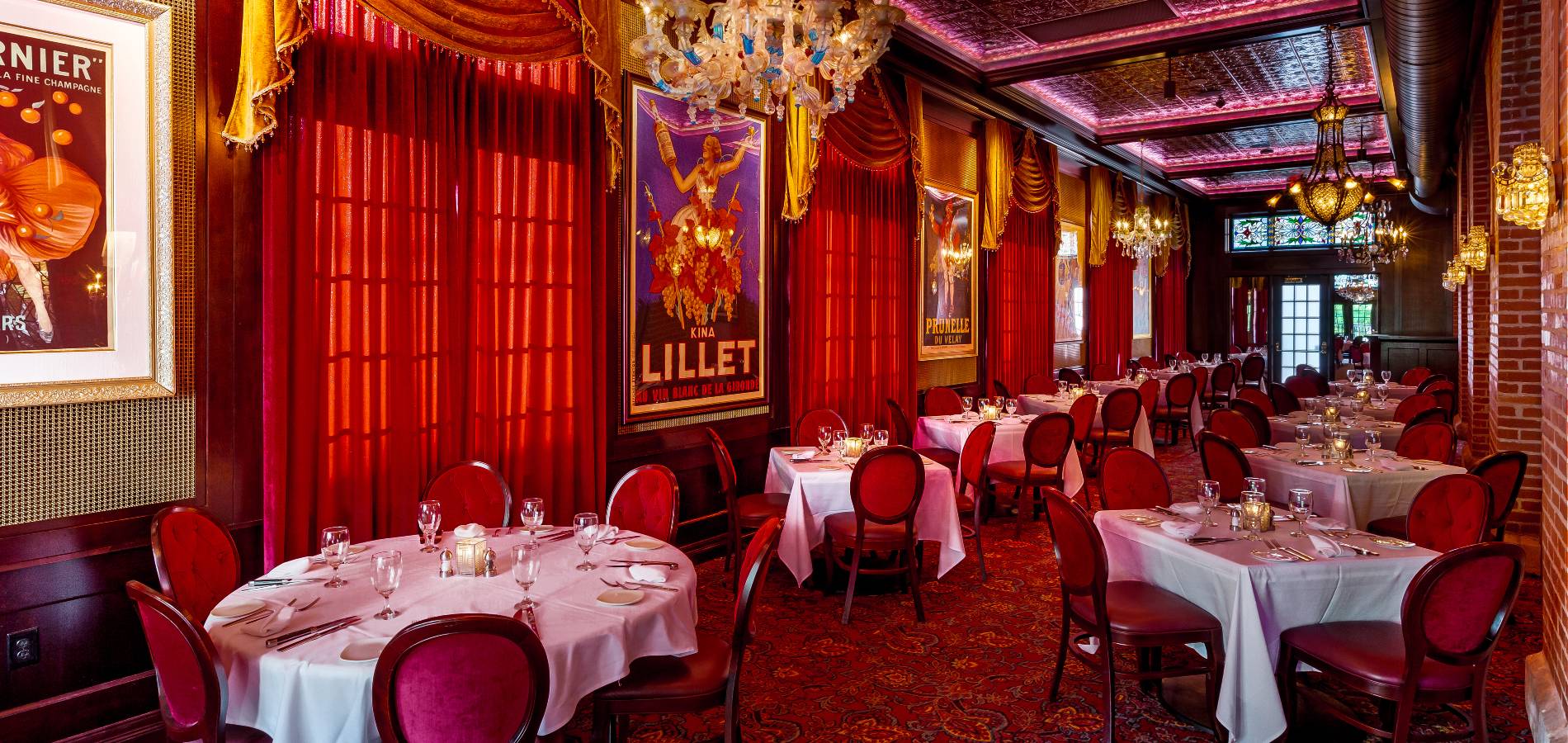 Venetian Room at Jeff Ruby's Steakhouse Columbus with red drapes, round tables and chandeliers