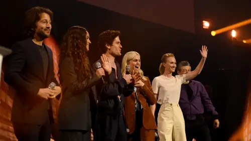 The Andor cast smiling and waving onstage at Star Wars Celebration