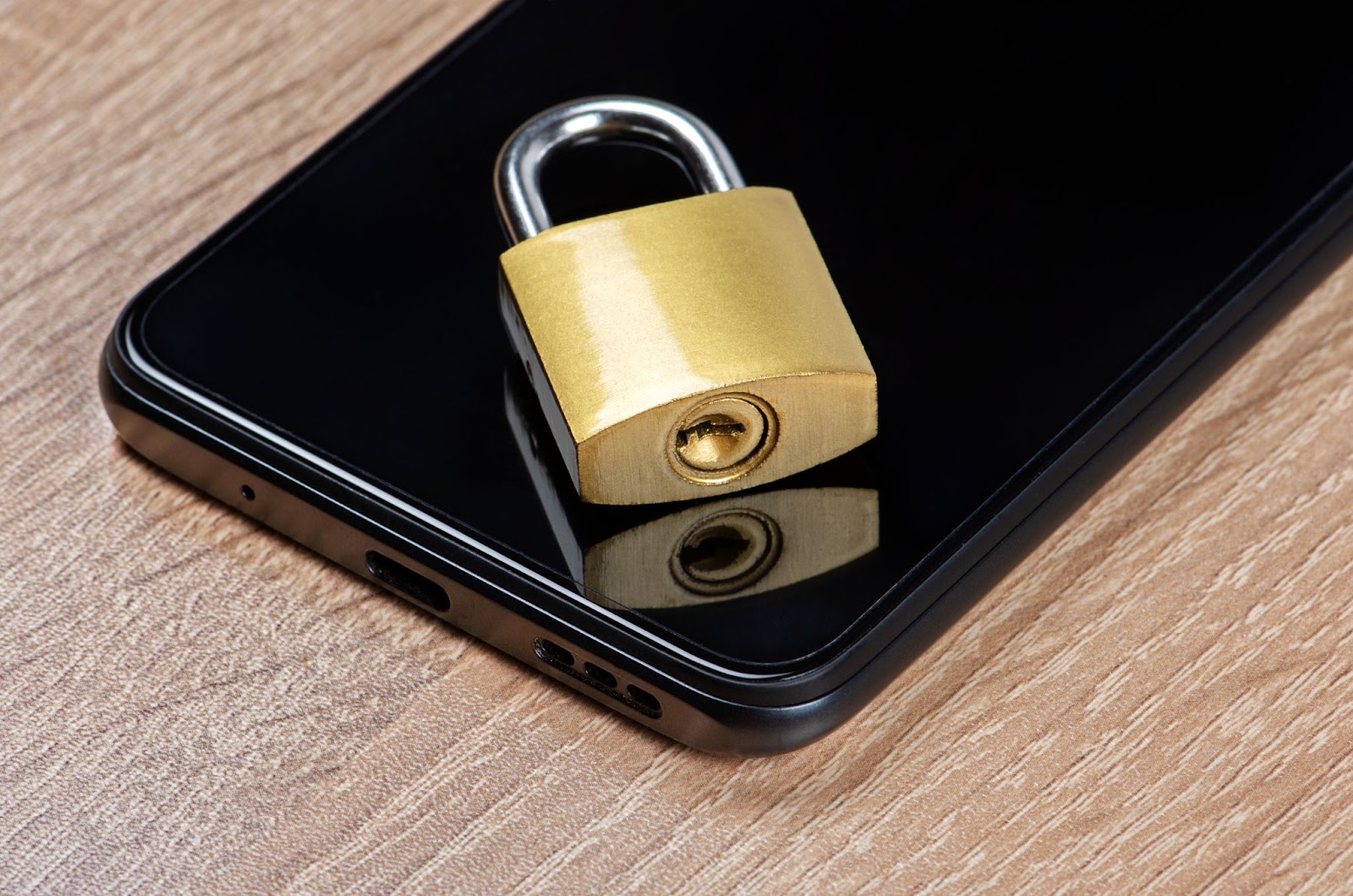 Lock on a cell phone with a wooden surface in the background. 