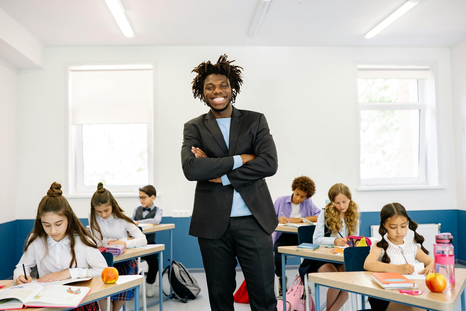 A smiling student gives a high-five to an educator after successfully completing a reading assignment.