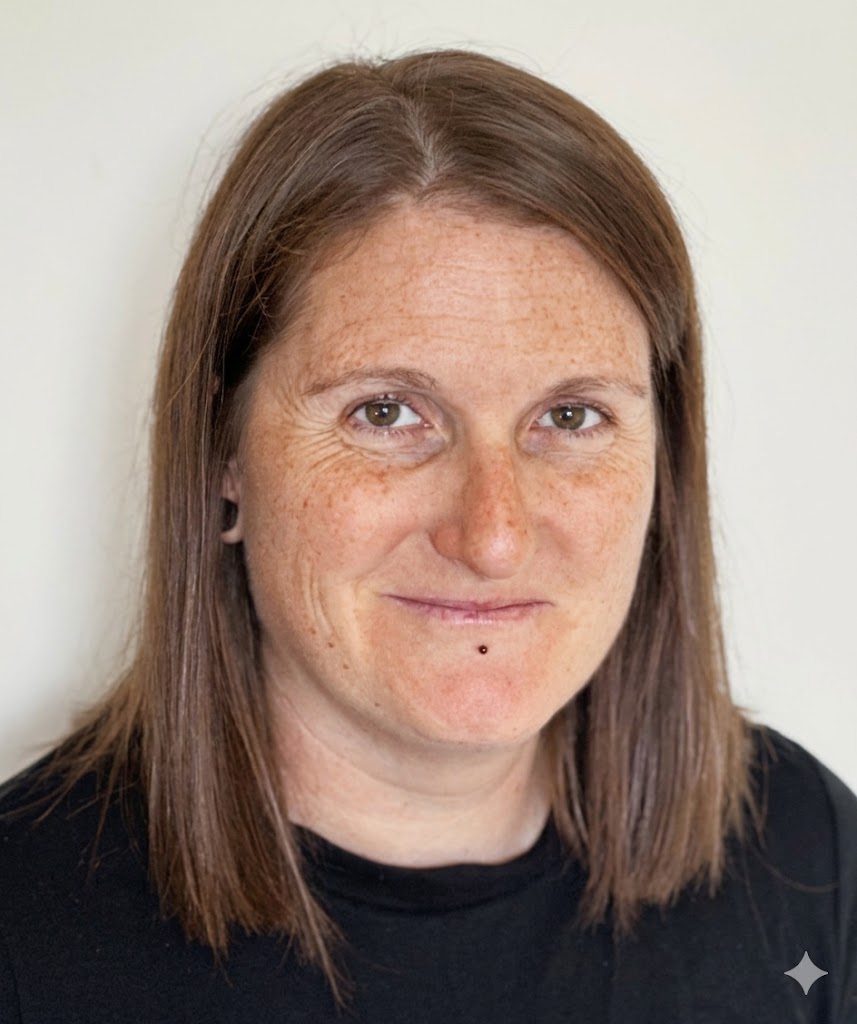 Professional headshot of a person with shoulder-length brown hair, facing forward against a plain light background.