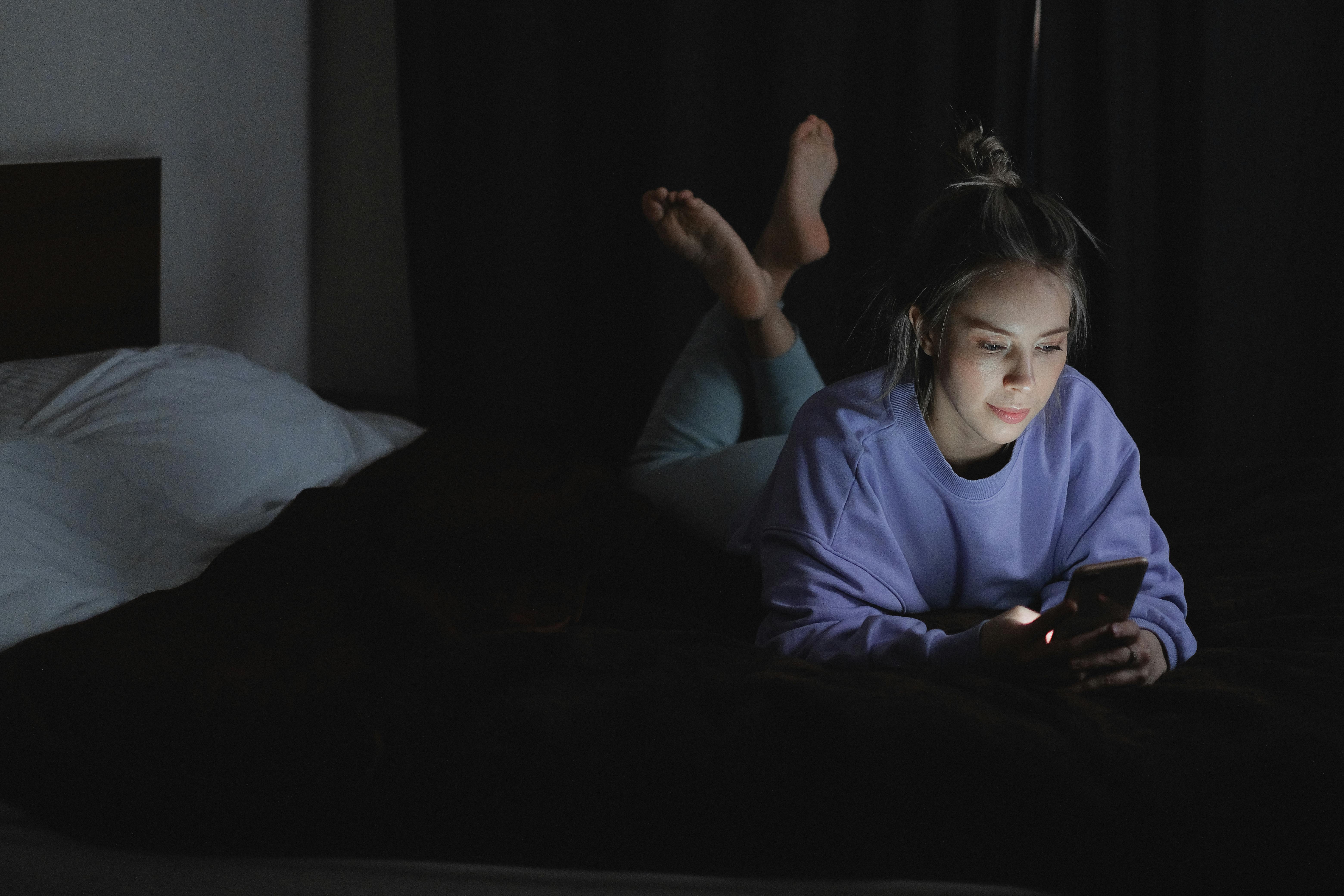 Photo by SHVETS product-woman-lying-on-bed-while-using-a-cellphone