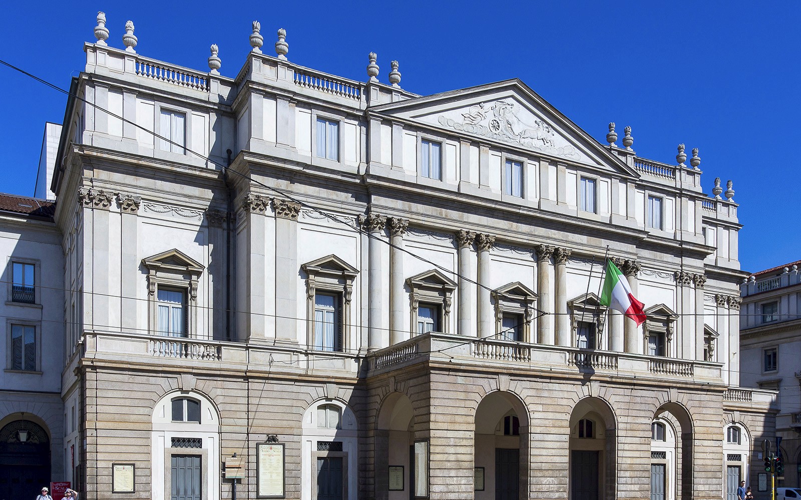 La Scala Theatre facade in Milan with Italian flag.