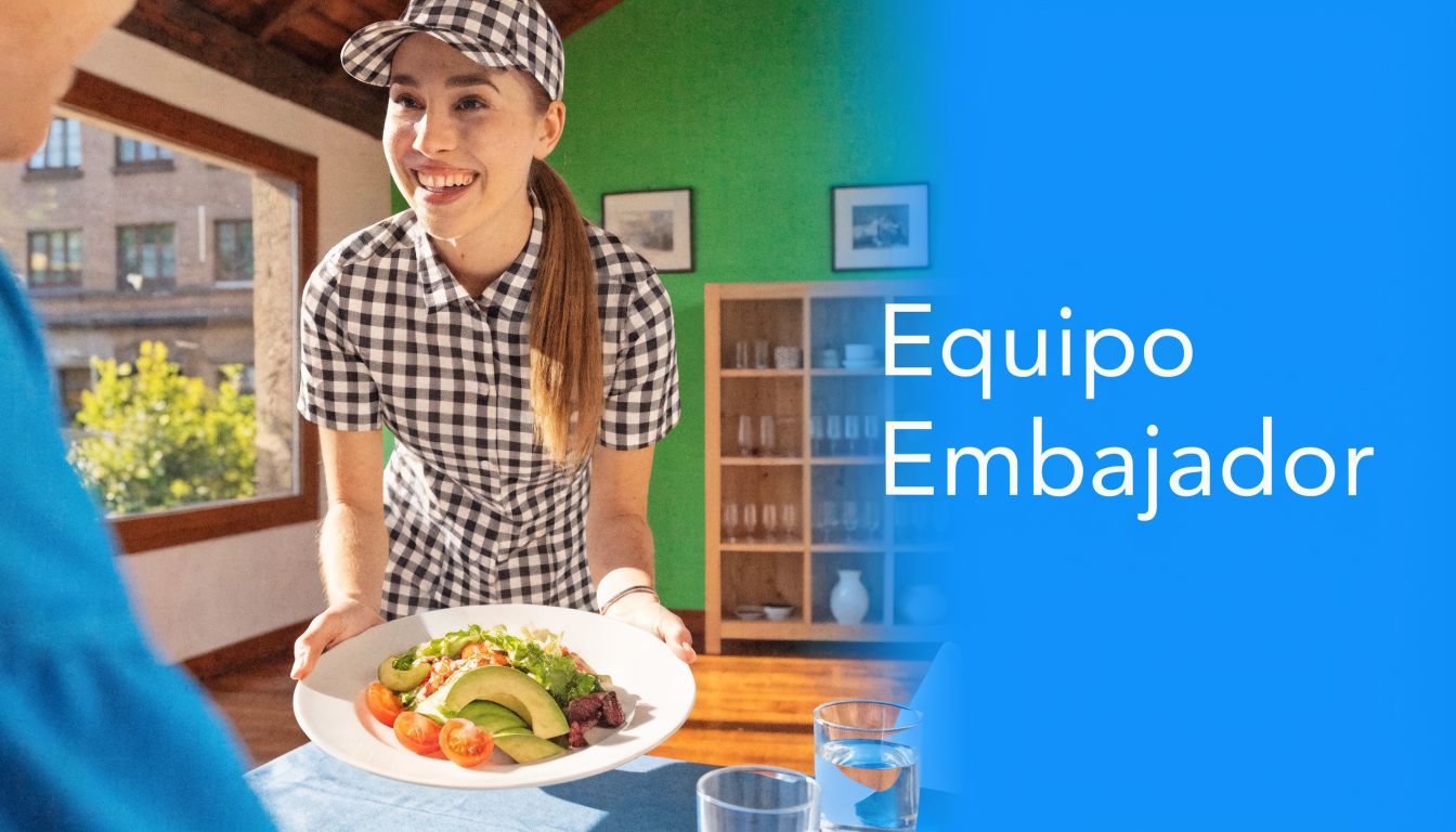 Una sonriente camarera uniformada entrega un plato de ensalada fresca y saludable a un cliente en un restaurante.