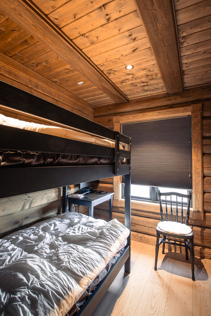 Small bedroom with wooden bunk beds in a 72 sqm log cabin.