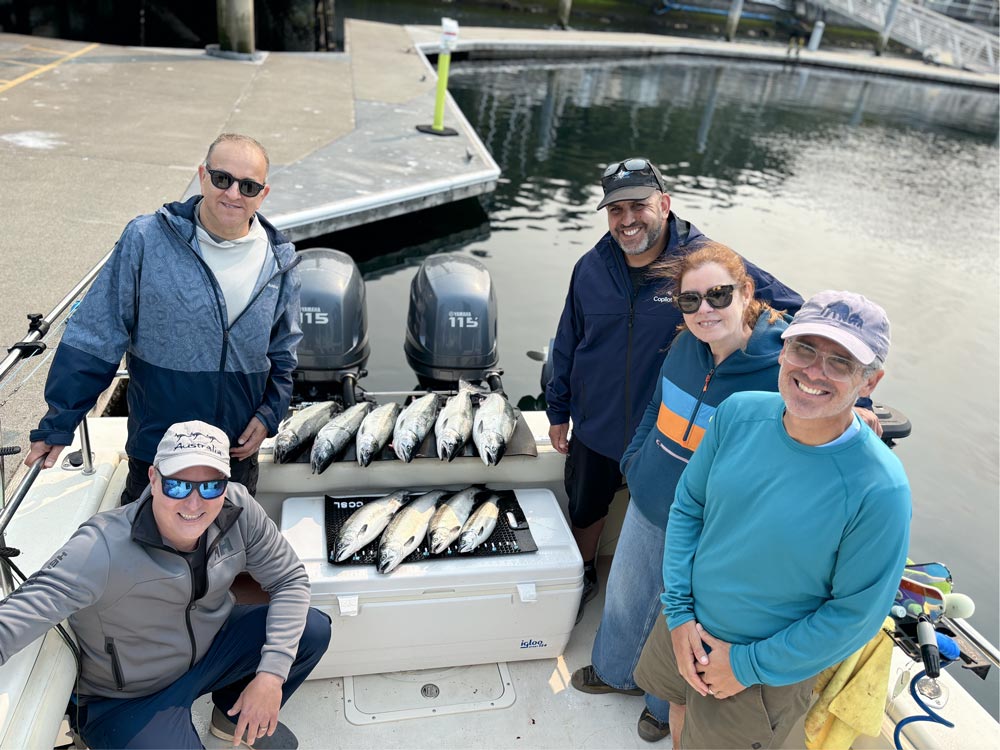 Large group posing with their salmon at a seattle fishing charter boat