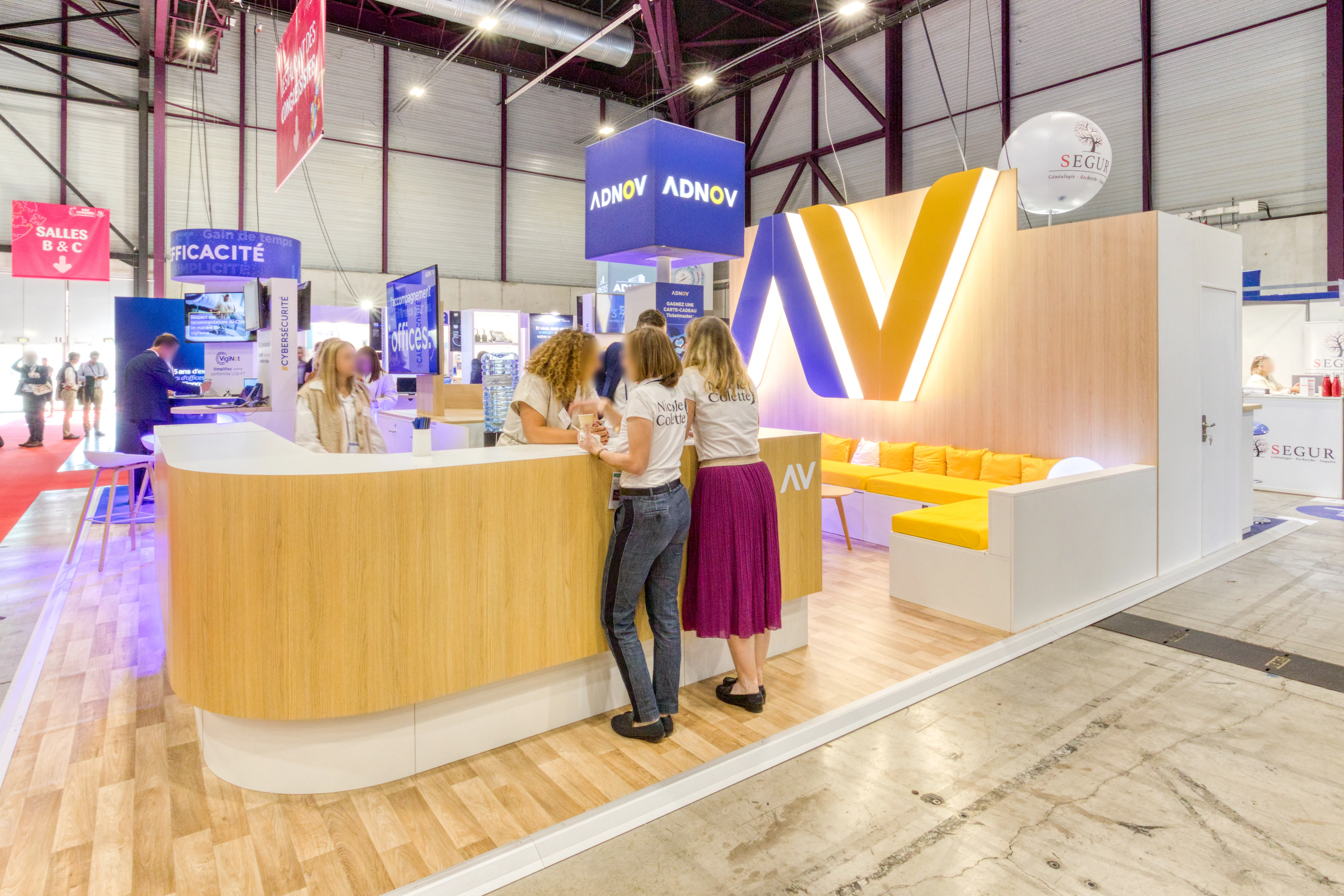  Stand ADNOV au Congrès des Notaires 2025 conçu par Expace, avec accueil en bois clair et logo rétroéclairé 