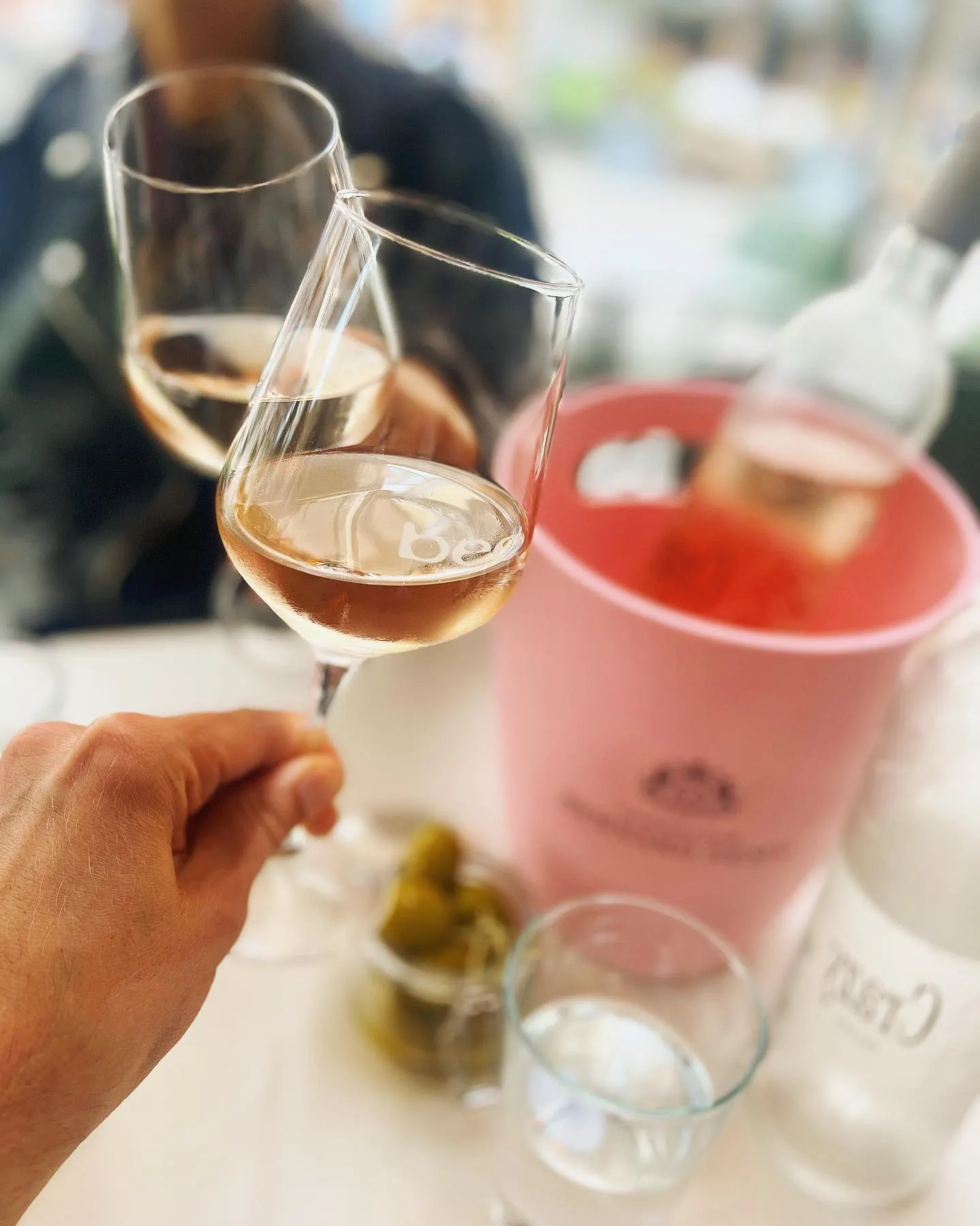 Två glas med rosévin står på ett bord i Bee-prydda vinglas.
