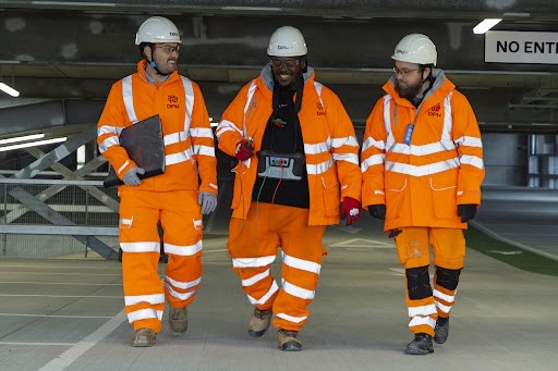 Modern glass buildings with illuminated facades and trees on a rainy day
