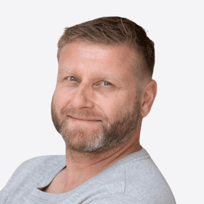 Headshot of employee, Remco Westerbroek, on a blue tinted, grey background