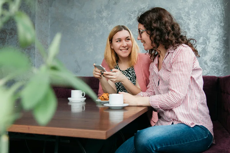 Two Women at a cafe having coffee.