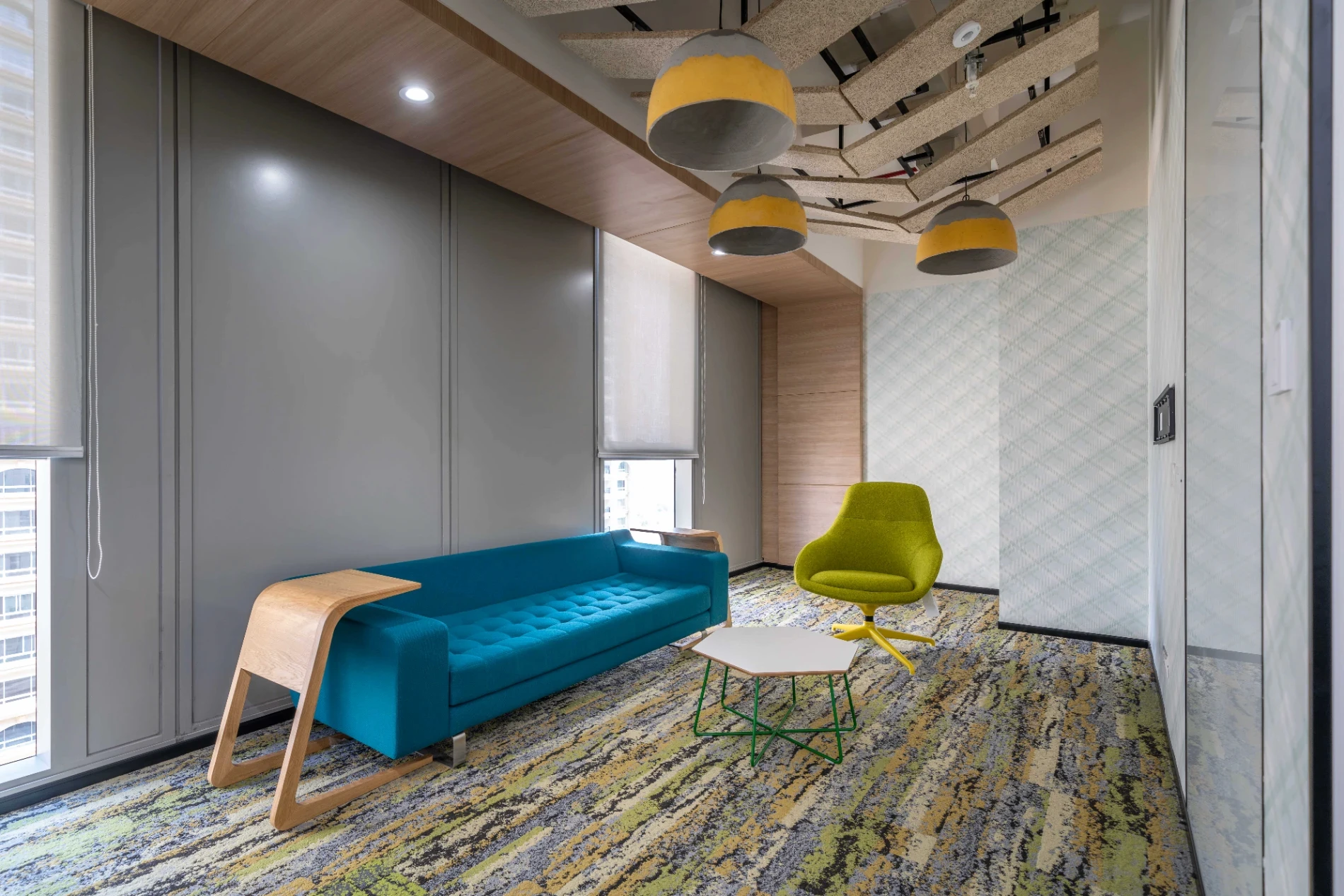 Collaboration area designed for workspace with colorful seating and high ceiling and carpet 