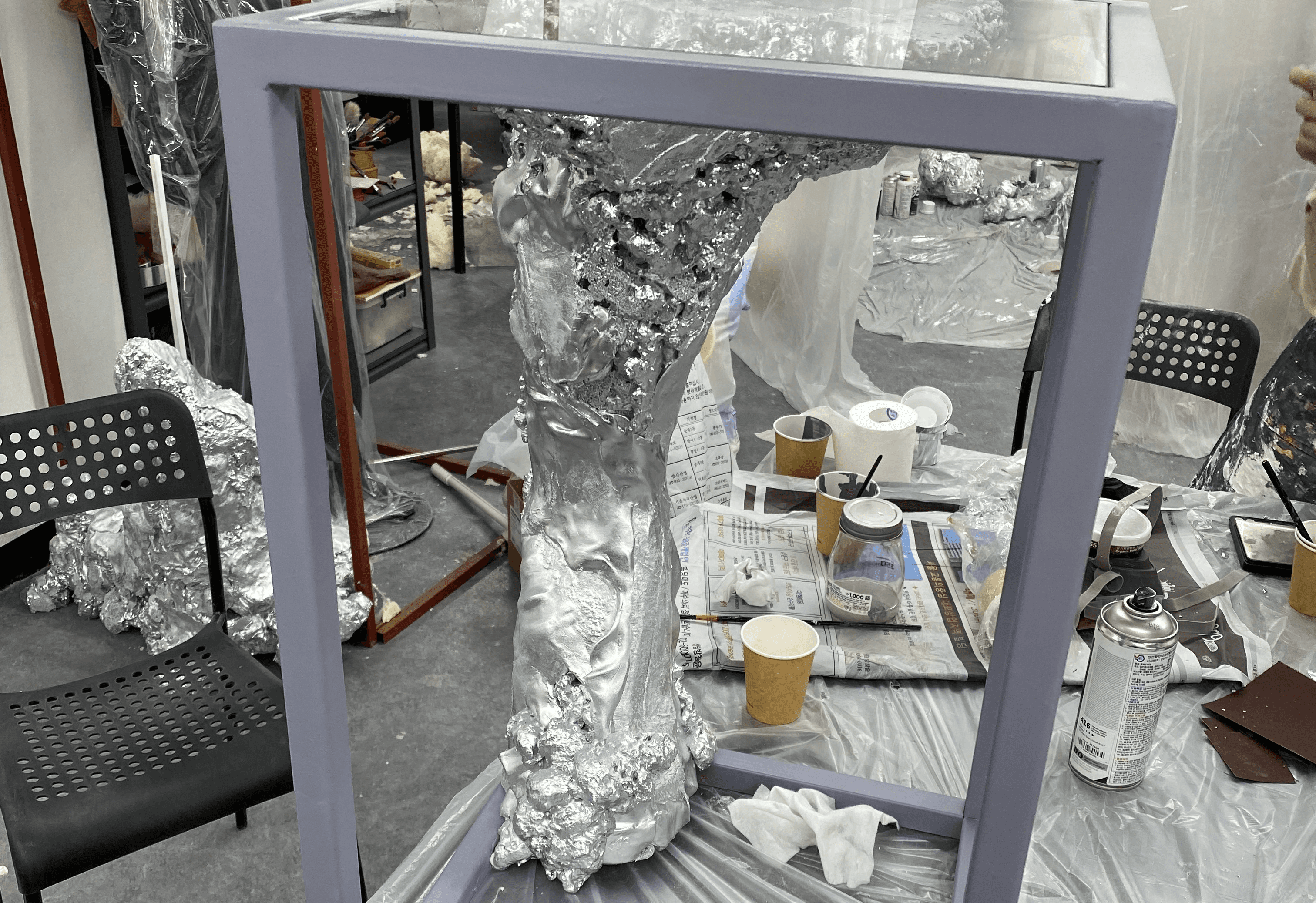 실버 메탈릭 도색 완료 후 철 프레임 좌대에 안착된 조형물 / Sculpture with silver metallic finish seated on steel frame pedestal