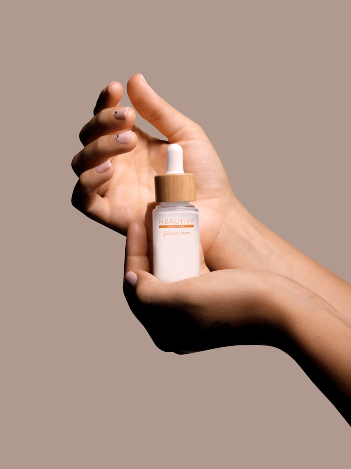 A hand cradling a small skincare bottle against a mauve backdrop