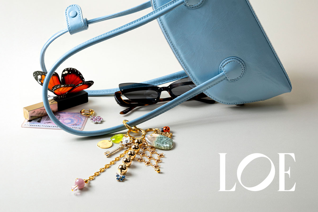 photographie de bijoux de sac fantaisie sur sac à main bleu pour campagne de marque de bijoux