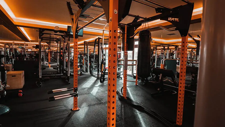 Red wooden harbor house overlooking boats, water, and snow-capped mountains.