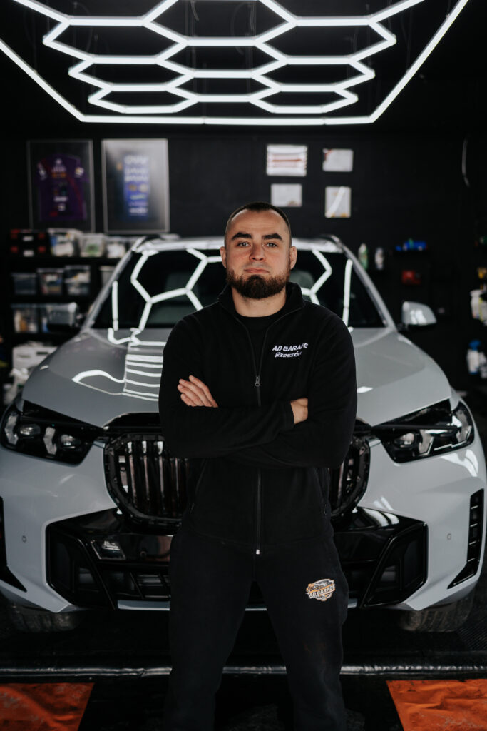 Young man with dark curly hair and beard, smiling.