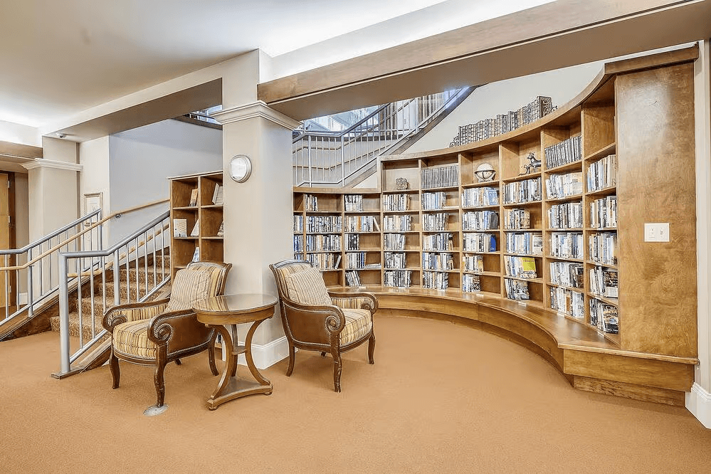 Cozy shared lounge with a small library of books and magazines for memory care and assisted living residents.