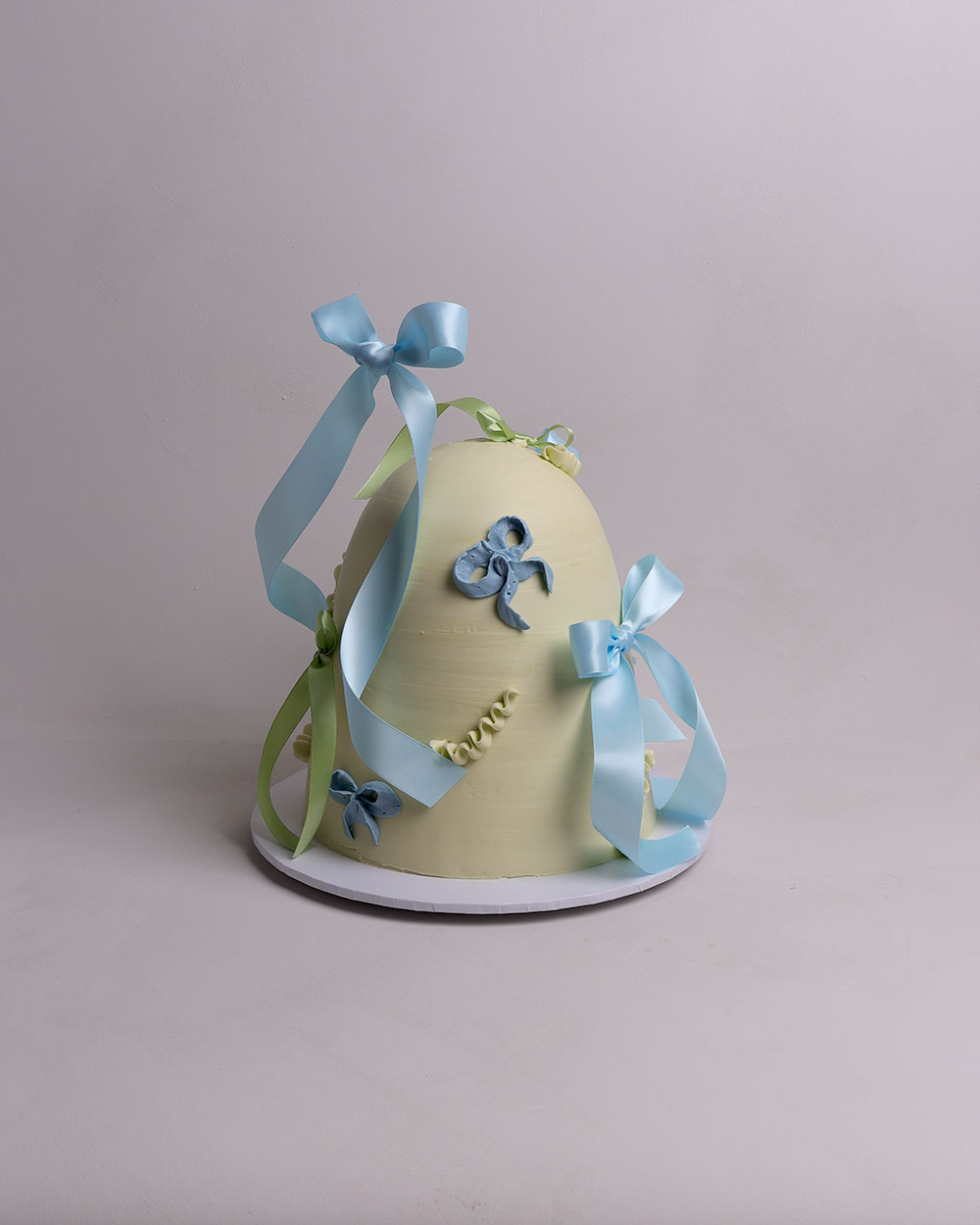 abstract dome cake with fresh flowers in peach and green tones