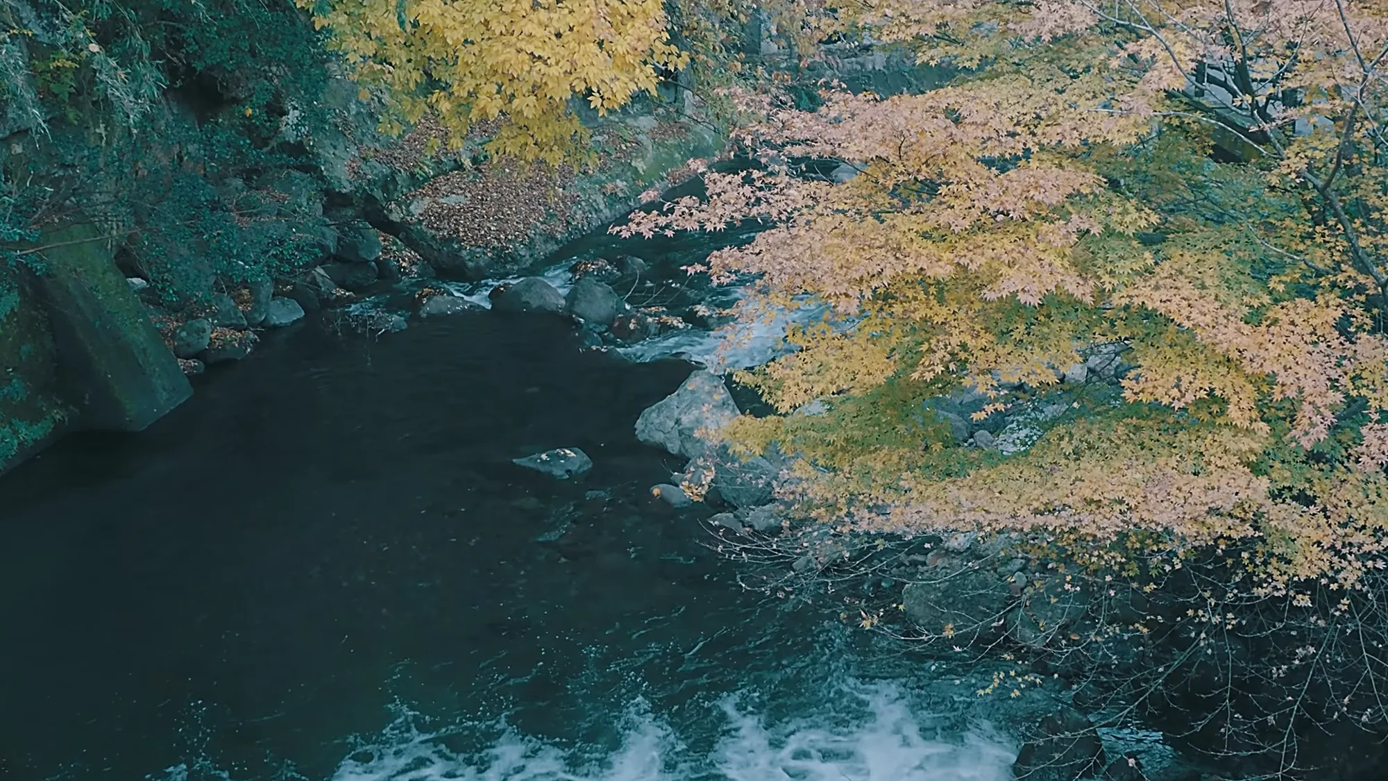 The river at Kurokawa Onsen from above, colour on both banks