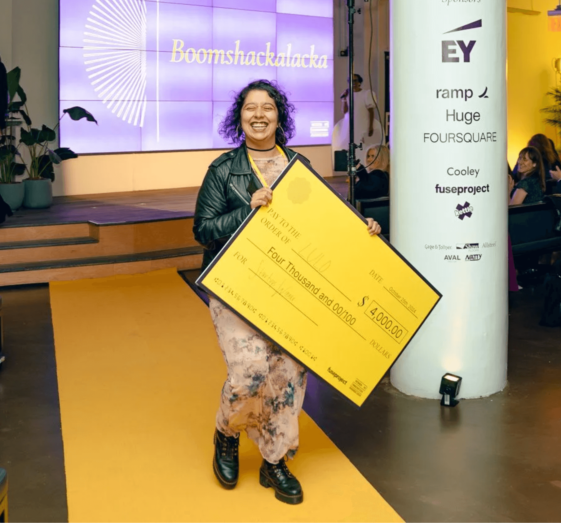 A group of people sitting in a row, attentively listening during a presentation or discussion.