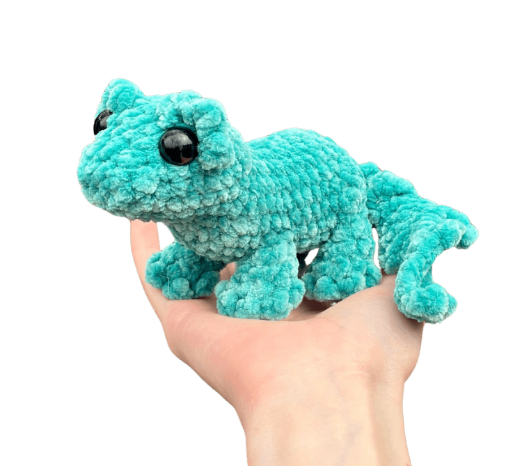 A cute, handcrafted plush hedgehog toy with brown yarn spikes and large, friendly eyes sits facing forward on a white background.
