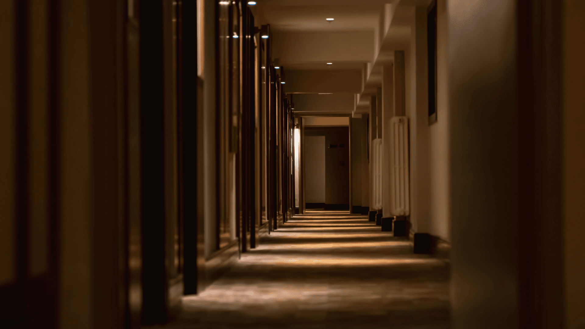Warmly lit hotel corridor with soft shadows and refined interior design | Lunasole Hospitality