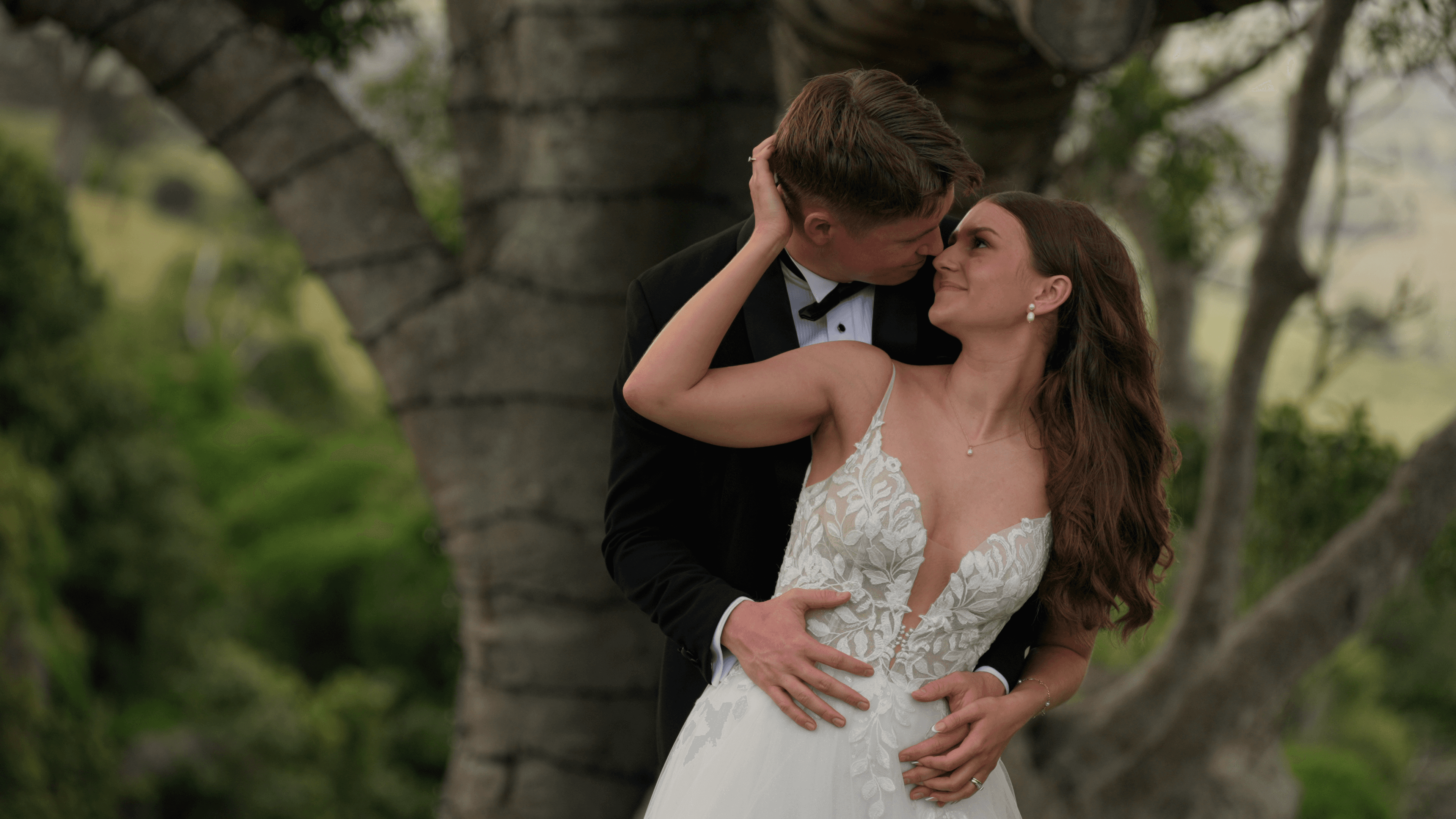 Nicaela and James during their after ceremony portrait session in front of the large fig tree at Western Ridge, Glenmorgan Vale