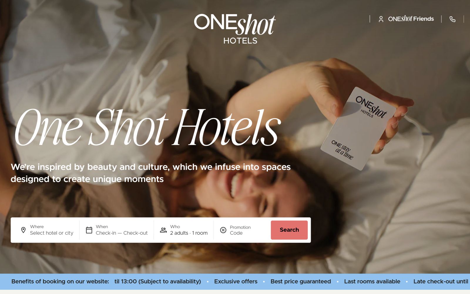 Woman lying on bed holding room keycard. Text: "ONEshot HOTELS," "One Shot Hotels," with search bar below.