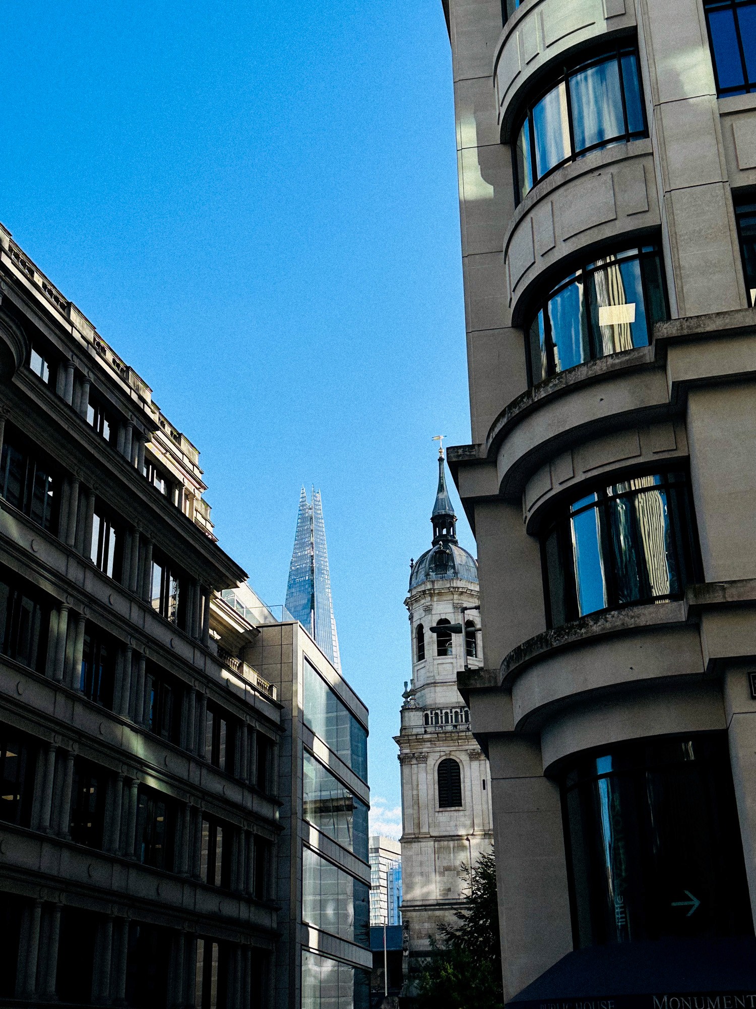 Modern brick and glass building reflecting the blue sky, with pedestrians and cyclists moving through a sunlit urban plaza, creating dynamic motion blur effects.