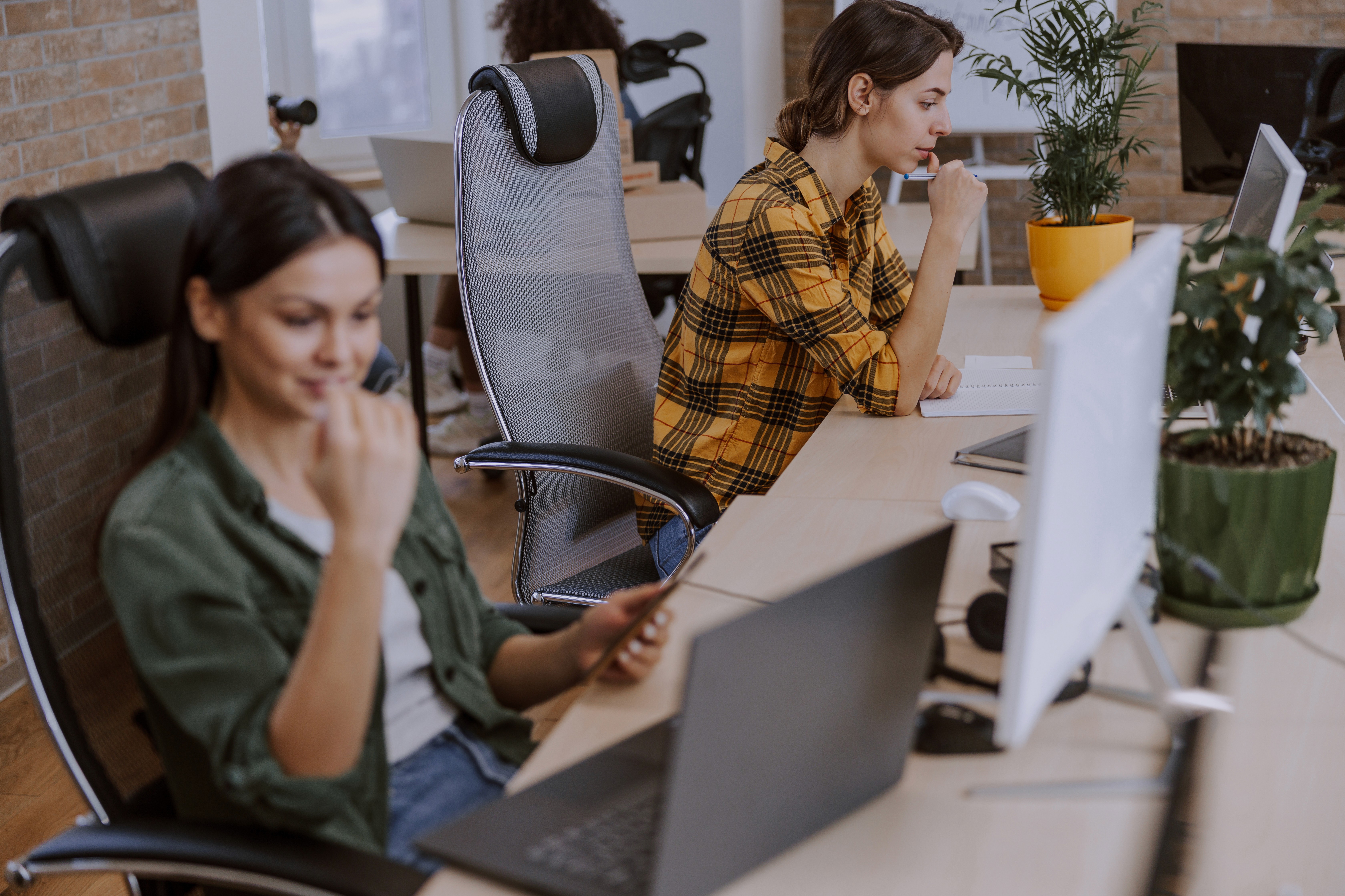 Two women working at a modern desk.