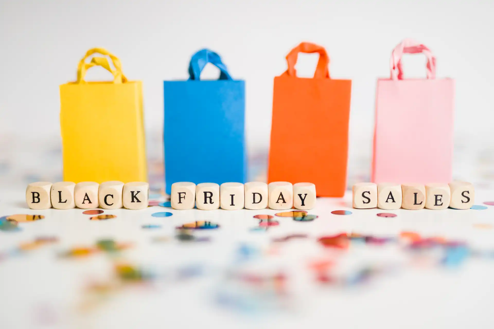 Colorful shopping bags and Black Friday blocks symbolizing TikTok Shop peak season sales opportunities for brands.
