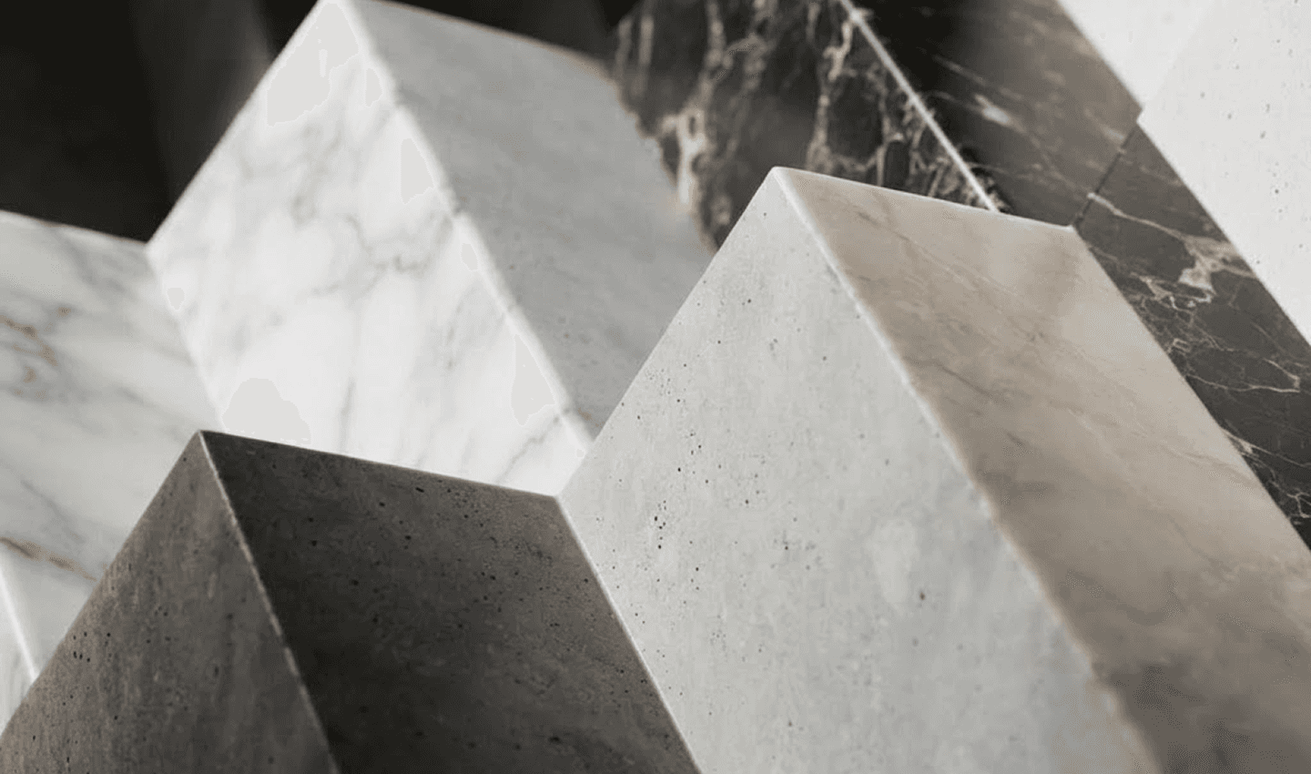 Close-up of geometric blocks in contrasting white, gray, and black marble.
