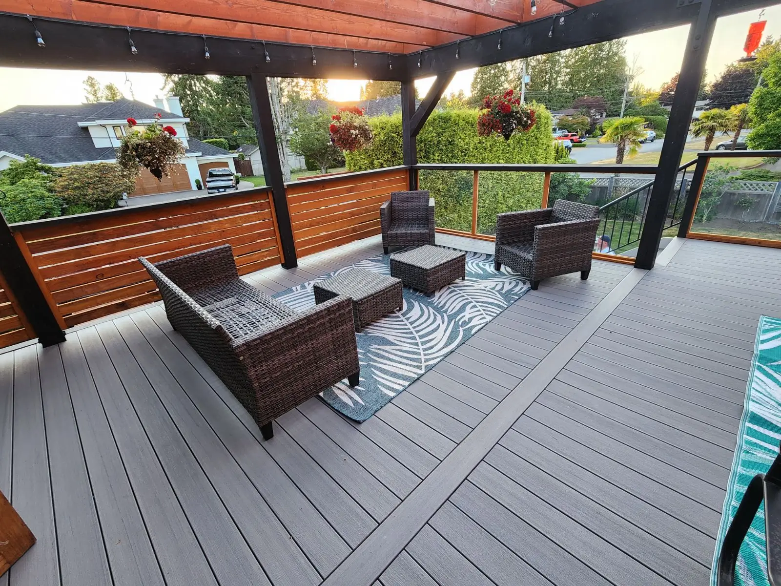Modern outdoor living space with covered deck, seating area, and wood pergola.
