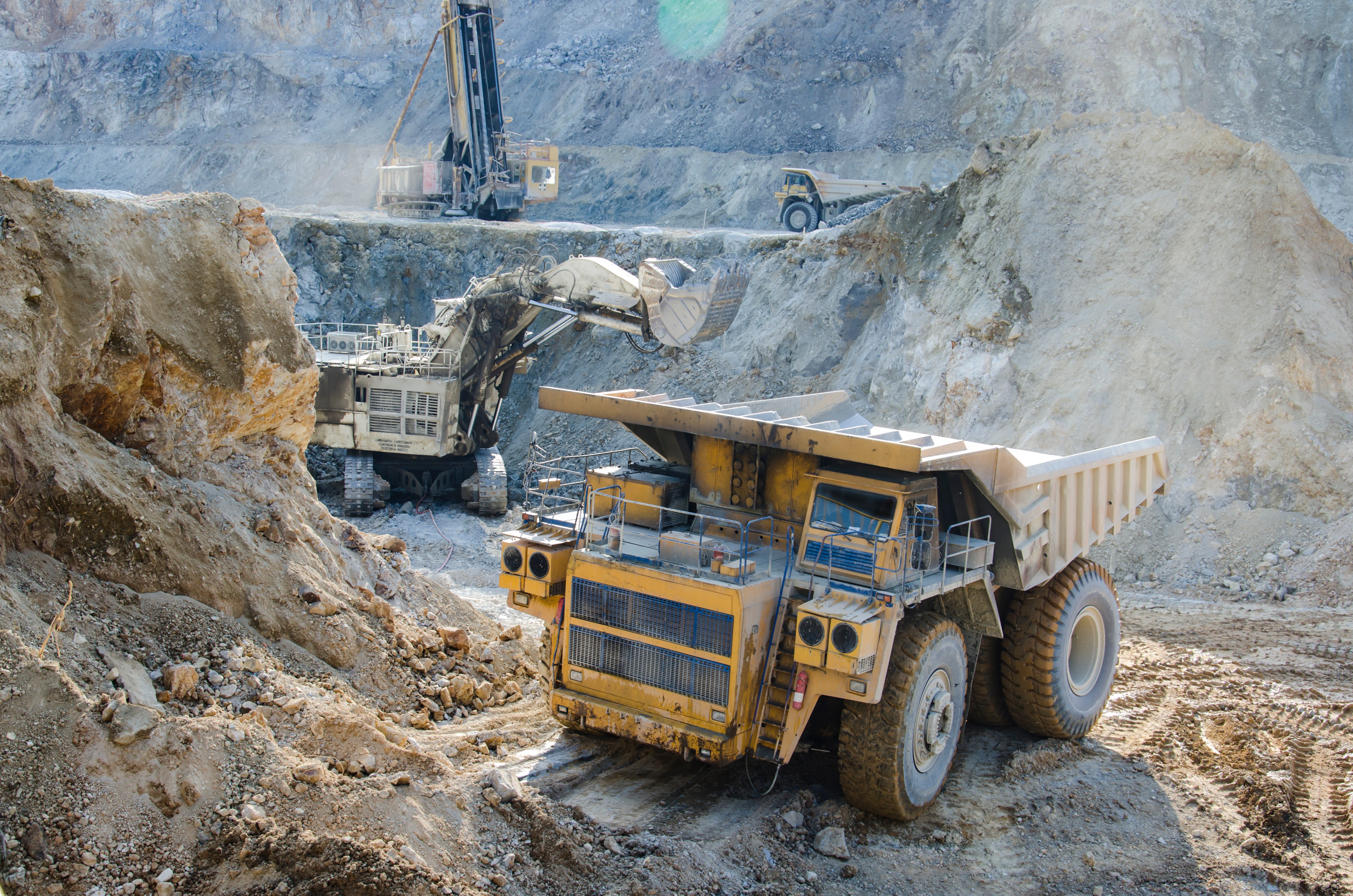 Large haul truck being loaded by a mining shovel excavator in an open-pit mine
