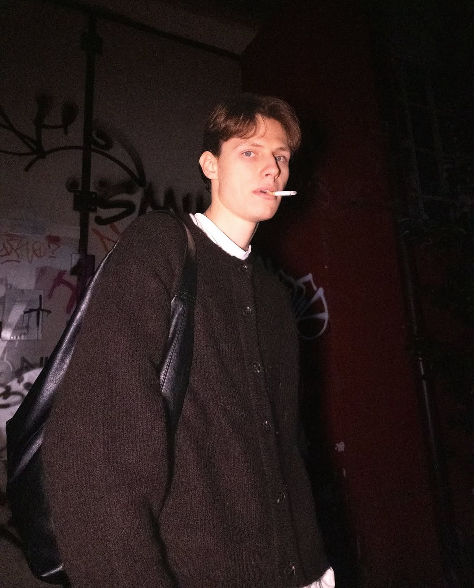 young man smoking cigarette in hallway